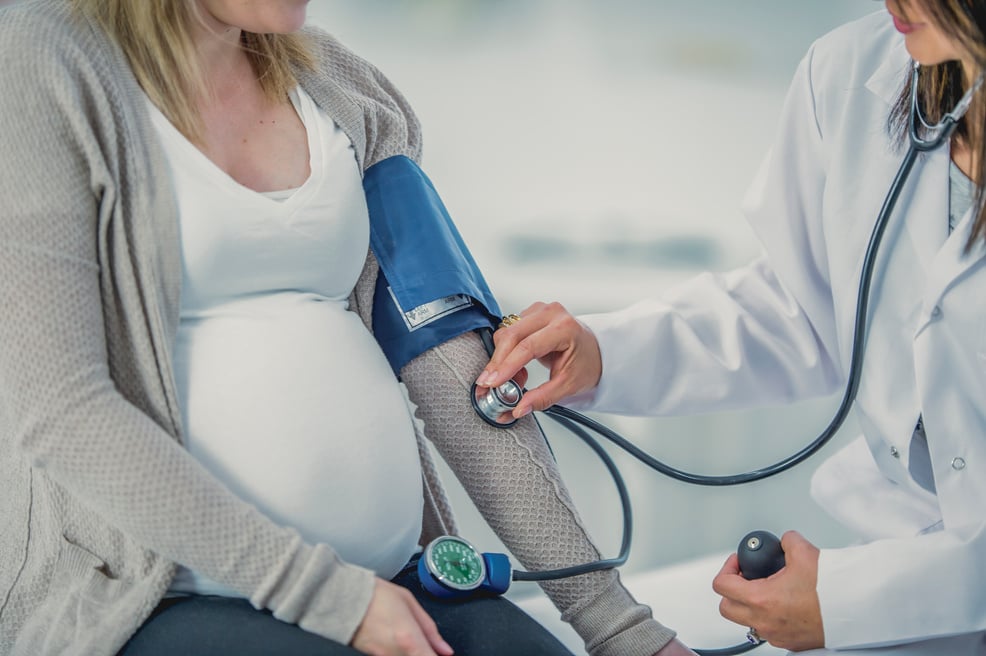 Doctor Examining a Pregnant Woman with Stethoscope