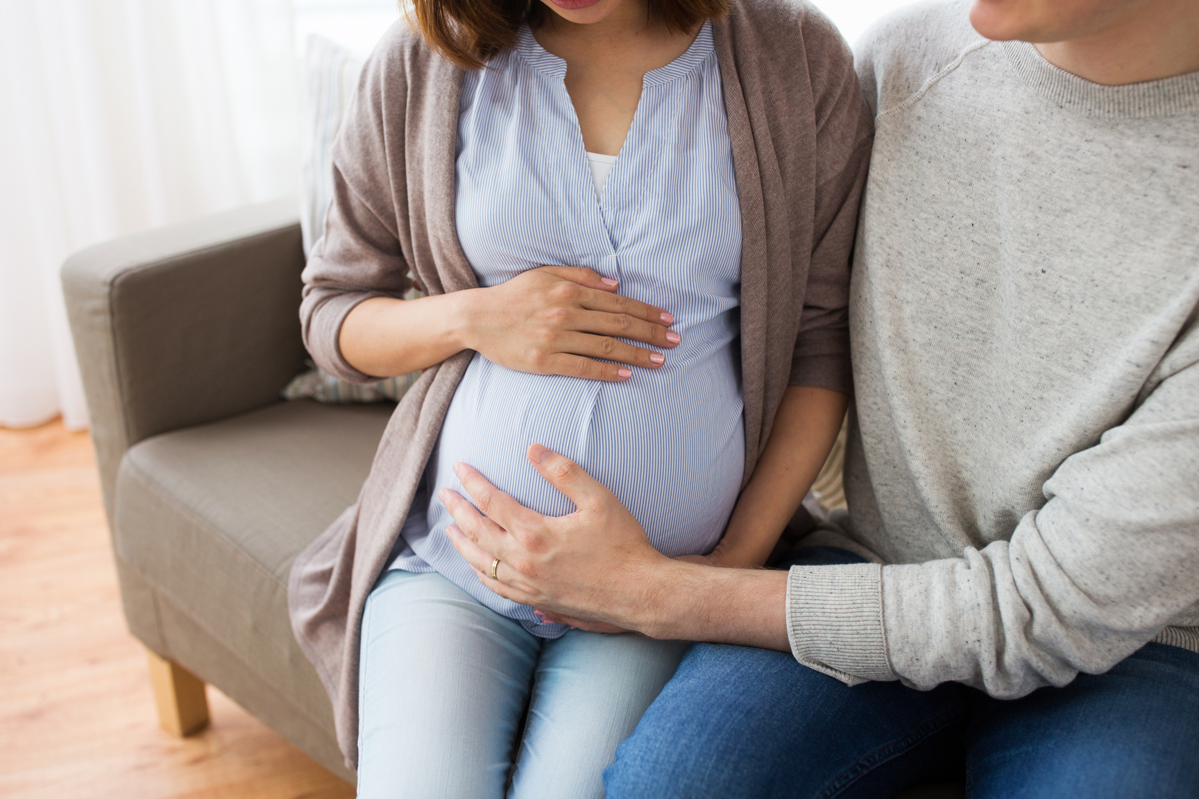 Pregnant Couple Embracing Each Other on the Sofa